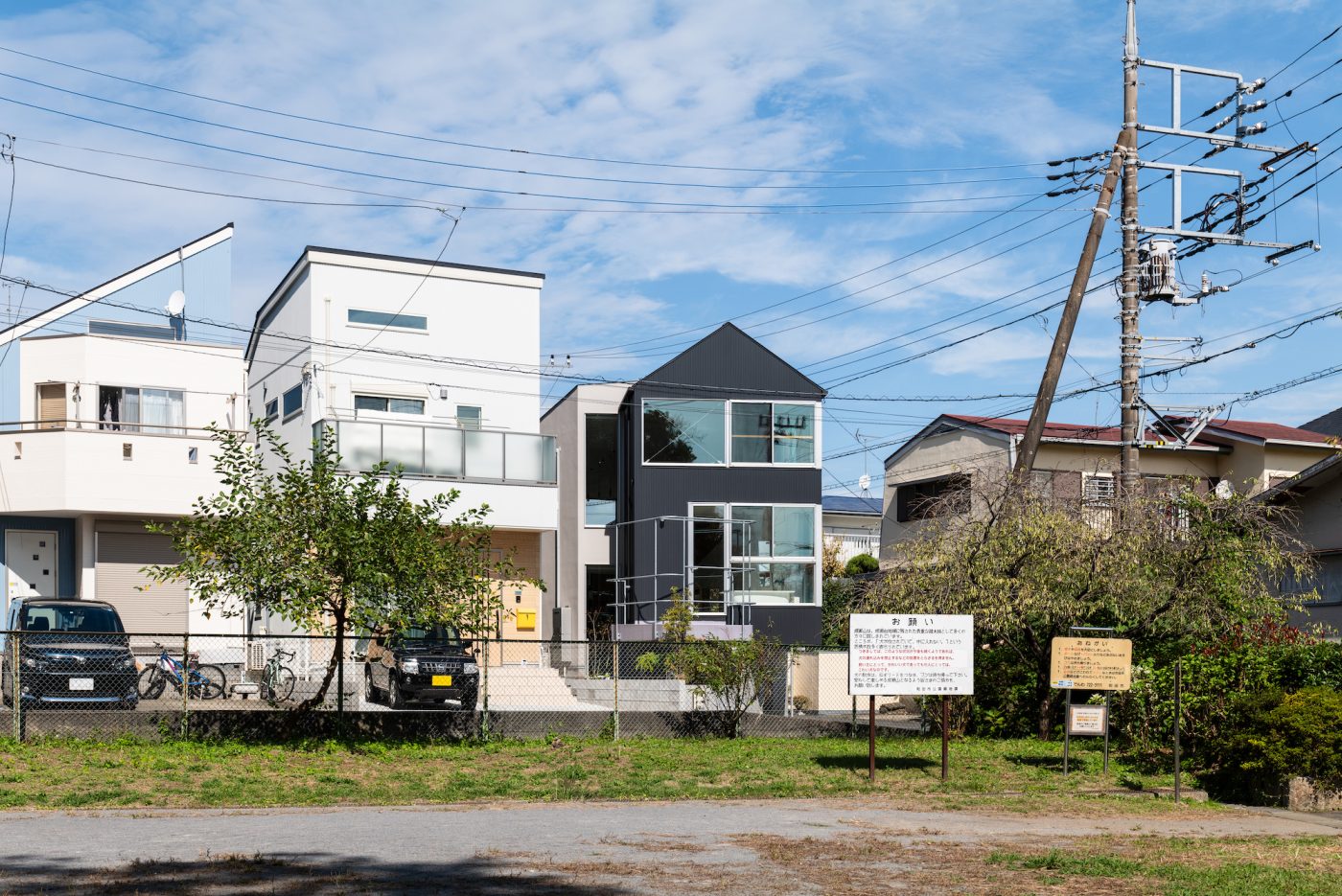 緑地から建物を見る。緑地は散歩や外遊びの場として周辺住民の日常に溶け込む共有の庭のような場所。