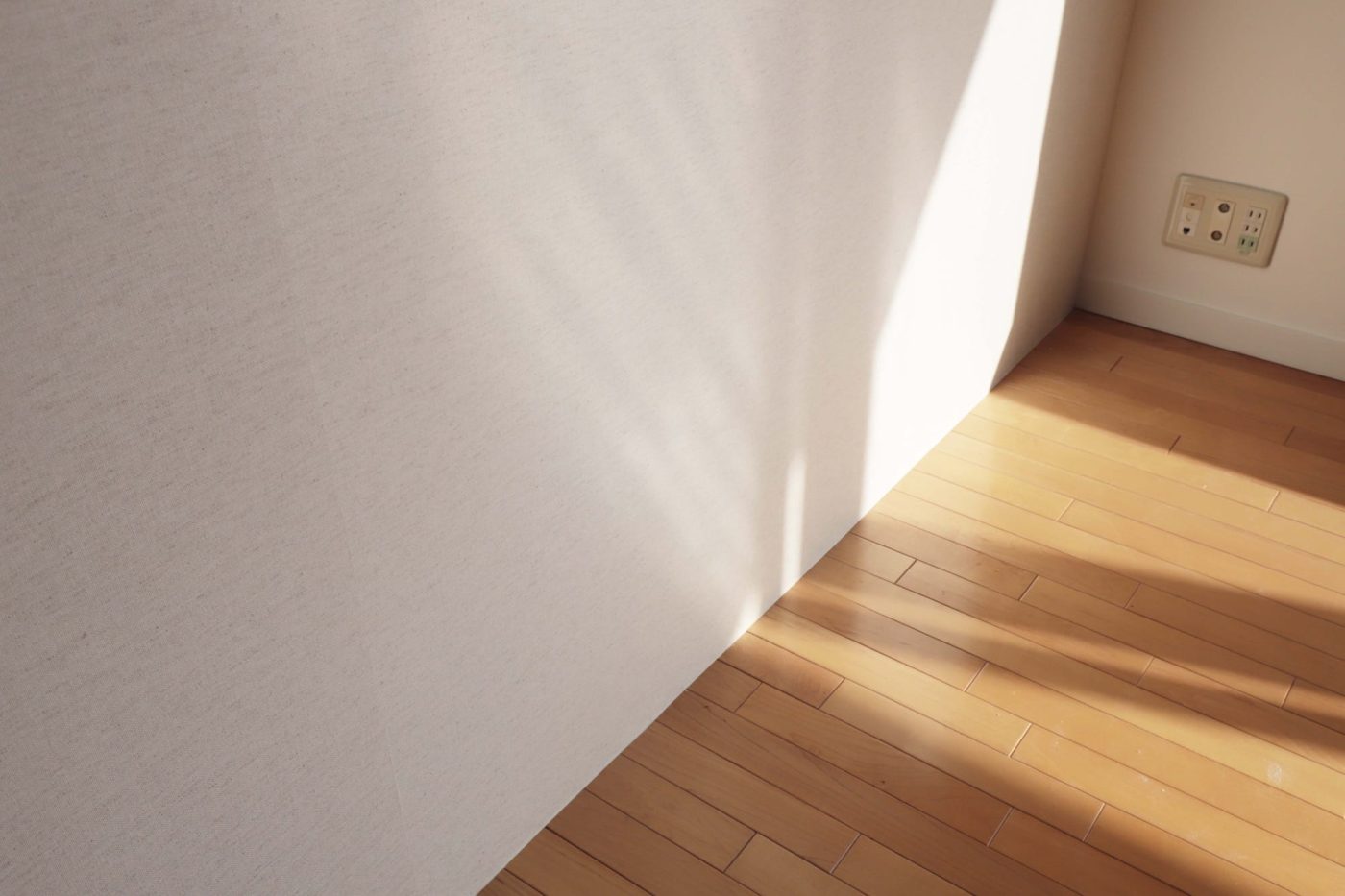 メープル材のフローリングと織物壁紙の組み合わせは部屋全体に暖かみを与えてくれます。