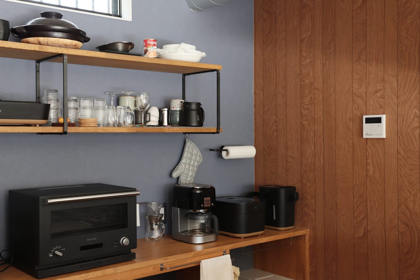 ブラックで揃えたキッチン家電が、鉄製の棚受けやペーパーホルダーに馴染みます。